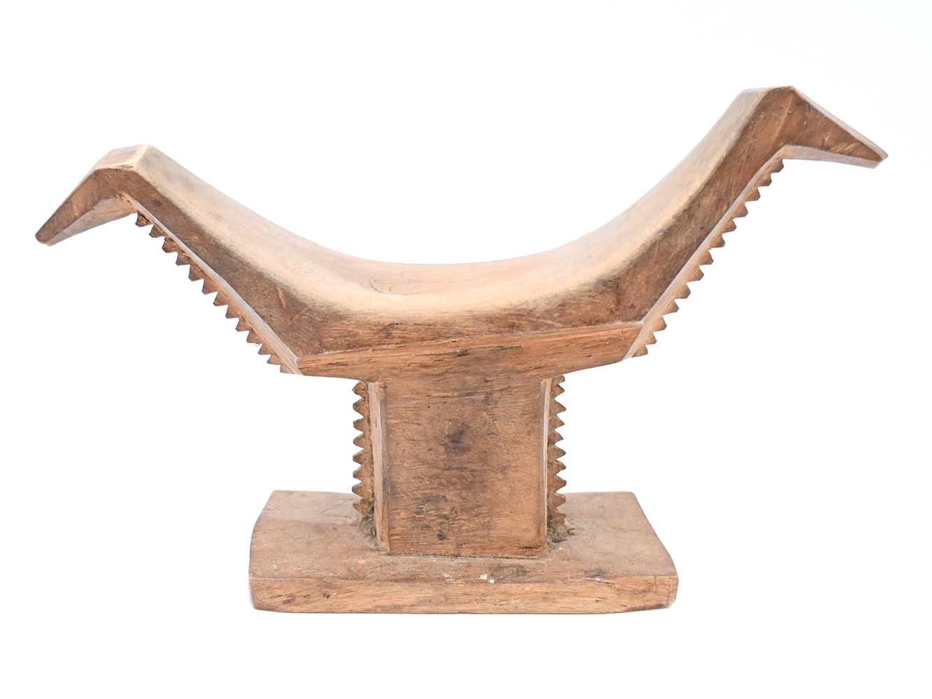 wooden headrest with serrated edges on base and abstract bird shaped sides of the cradle
