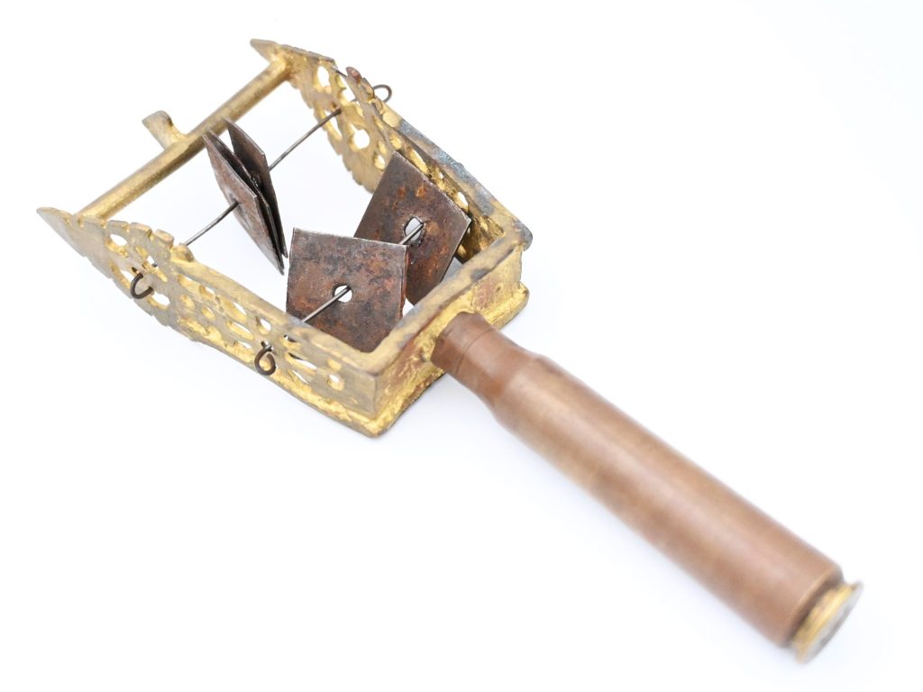 Handle with u-shaped frame and metal pieces strung across the frame